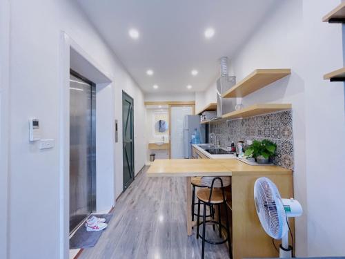 a kitchen with a counter and chairs in a room at Hanoi Home 2 - Lake View Apartment in Hanoi