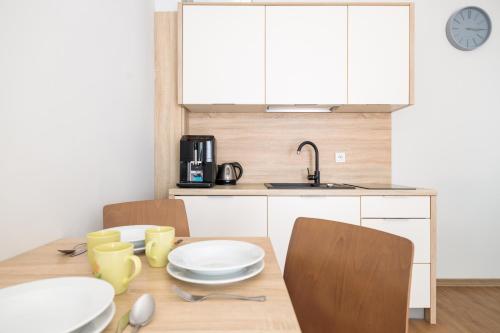 a kitchen with a table with chairs and a sink at Baltic Apartments in Pobierowo