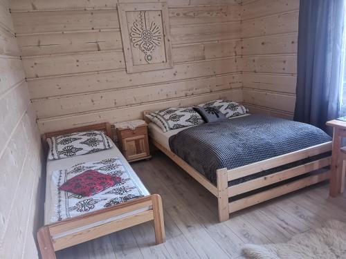 sypialnia z dwoma łóżkami w chacie z bali w obiekcie Zakopianskie Pokoje u Eweliny w Zakopanem