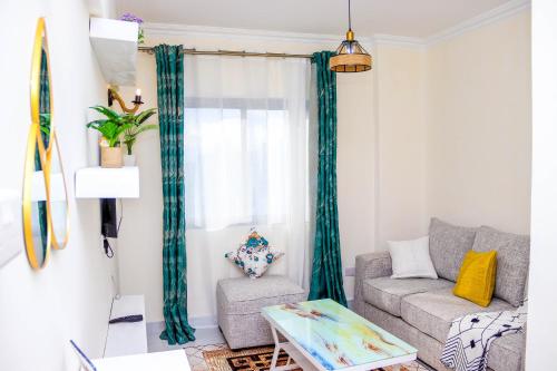 a living room with a couch and a table at Comfort & Style 1Bed Apartment, Luxore, Syokimau in Nairobi