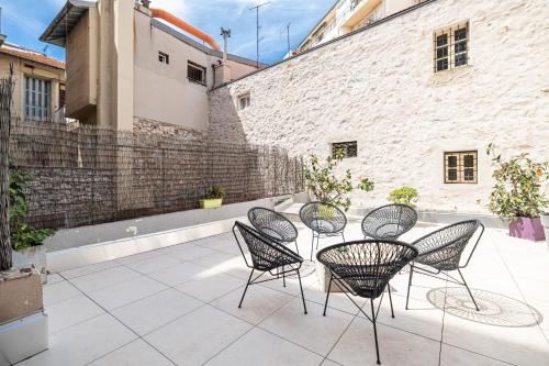 un groupe de chaises et une table sur une terrasse dans l'établissement Amazing 3 Bdrs and Garden Place du Pin Parking !, à Nice