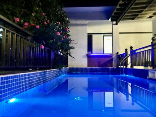 a swimming pool with blue lighting in a building at A Thía homestay in Diện Biên Phủ