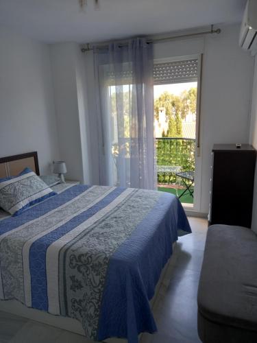 a bedroom with a bed and a large window at Apartamento Golf in Roquetas de Mar