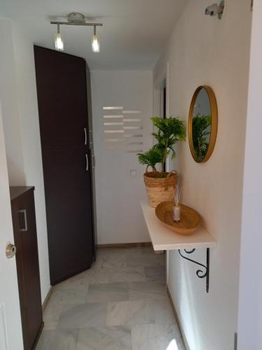 a hallway with a black door and a mirror at Apartamento Golf in Roquetas de Mar