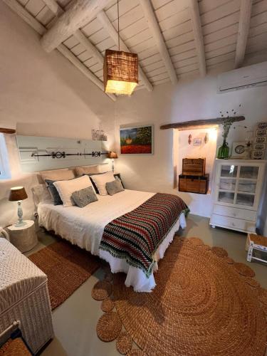 a bedroom with a large bed and a rug at Monte Refúgio do Silêncio in Portalegre