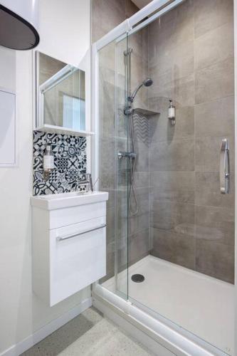 une salle de bain avec une douche avec une porte vitrée dans l'établissement Appartement 3 proche de la gare et du centre ville, à Amiens