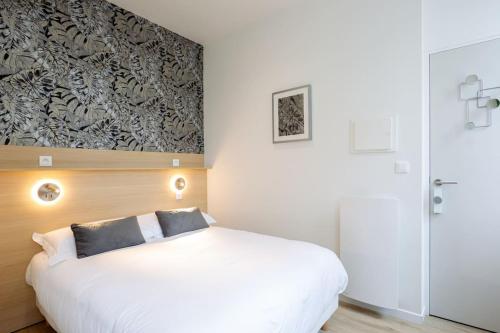 une chambre avec un lit blanc et un mur dans l'établissement Appartement 3 proche de la gare et du centre ville, à Amiens