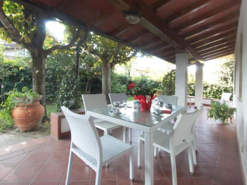 einen weißen Tisch und Stühle auf einer Terrasse in der Unterkunft Villa Lavinia by Interhome in Forte dei Marmi