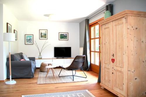 a living room with a couch and a tv at Ferienwohnung Oberammergau in Oberammergau