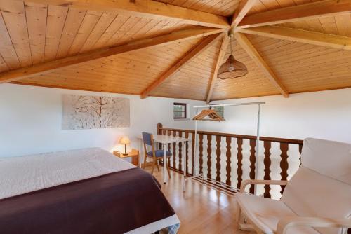 a bedroom with a bed and a wooden ceiling at Sesmarias MEL Casas Gémeas para Famílias Grandes in Cercal