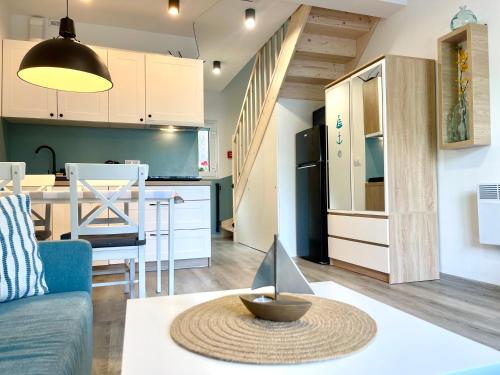 een keuken en een woonkamer met een bank en een tafel bij La Brisa Apartments in Dziwnówek