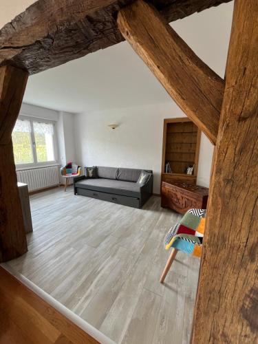 sala de estar con sofá y suelo de madera en Le Crozet, en Arçon
