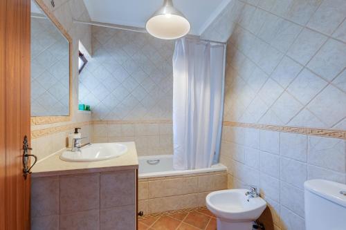 a bathroom with a sink and a toilet and a tub at Sesmarias MEL Casas Gémeas para Famílias Grandes in Cercal