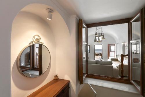 a bathroom with a mirror and a sink and a couch at 180° Caldera by Stylish Stays in Firostefani