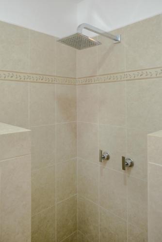 a bathroom with a shower with a shower head at Villas Picalu Lodge in Puerto Aventuras