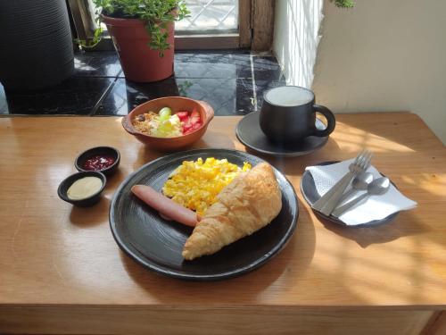 a plate of food with a hot dog and scrambled eggs at Suite Eugenia ubicada en el centro de Estreno in Cuenca