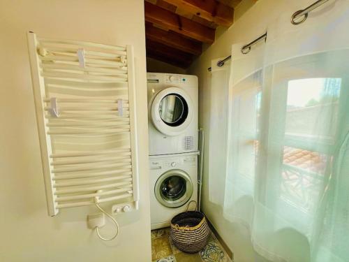 une buanderie avec une machine à laver et un lave-linge dans l'établissement La Peiro Malo - Charmant Duplex Centre Historique-CLIM-4 personnes, à Istres