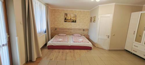 a small bedroom with a bed and a window at Aurora Ház in Zalakaros