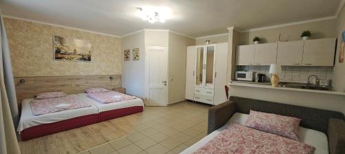 a small room with two beds and a kitchen at Aurora Ház in Zalakaros