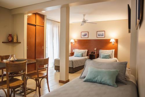 um quarto de hotel com duas camas e uma mesa de jantar em DonSuites em Corrientes