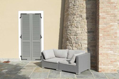 a white couch sitting in front of a brick wall at Casa Visette in Monforte dʼAlba