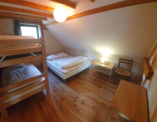 une chambre avec deux lits superposés et une table dans l'établissement Maison atypique et chaleureuse dans la nature, à Arras-en-Lavedan