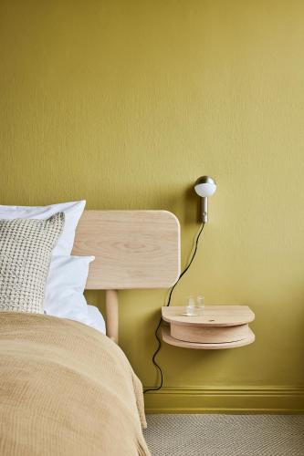 a bedroom with a bed and a night stand with a lamp at stilwerk Strandhotel Blankenese in Hamburg