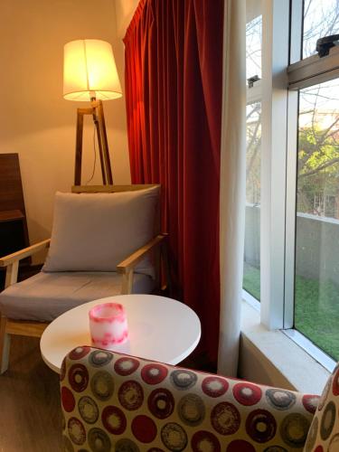 a living room with a table and a chair and a window at First Palermo Hotel in Buenos Aires