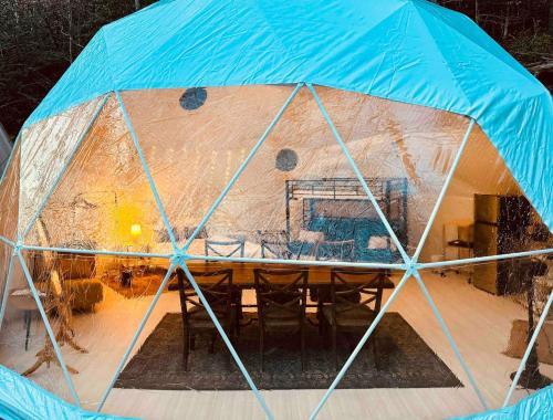 a tent with a wooden table inside of it at The Perch Glamping By Rafting in Cosby