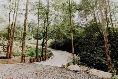a path through a forest with trees and rocks at The Perch Glamping By Rafting in Cosby