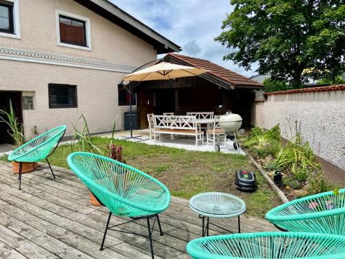 a group of chairs and an umbrella on a patio at Bäckerhaus - Wohnung mit Pool und Garten in Gmunden