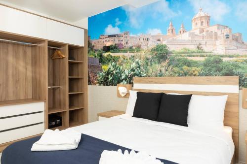 1 dormitorio con 2 camas y una pintura de un castillo en Ivory Suite Seafront With Views!- Fl 14 By Homely, en St Paul's Bay