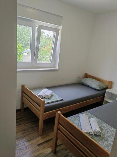a small room with two beds and a window at Holiday Home Višnja in Nin