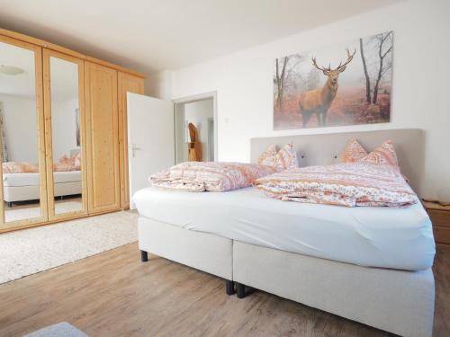 a bedroom with a bed with a deer picture on the wall at Haus Sunnseitn in Innsbruck