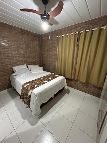a bedroom with a bed and a ceiling fan at Casa agradável em um condomínio na barra do sana. in Sana