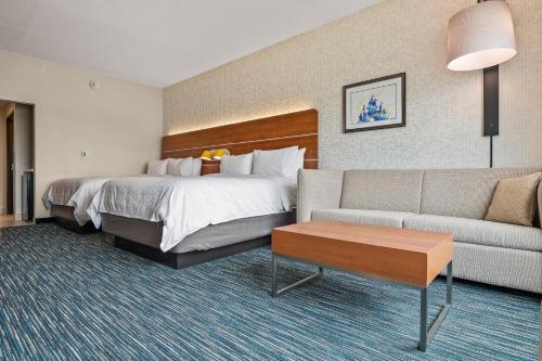 a hotel room with a bed and a couch at Holiday Inn Express & Suites Orlando- Lake Buena Vista by IHG in Orlando