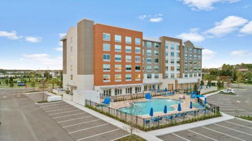 ein Apartmenthaus mit einem Pool vor einem Gebäude in der Unterkunft Holiday Inn Express & Suites Orlando- Lake Buena Vista, an IHG Hotel in Orlando