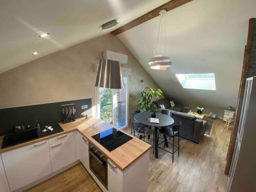 a kitchen and living room with a table and a dining room at appartement la fleur d'abeille avec une belle vue et spa in Gérardmer