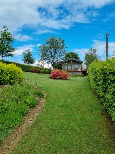 a garden with a house in the background at LAC ACHETTE AU LAC in Butgenbach