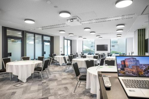 a conference room with tables and chairs and a laptop at Holiday Inn & Suites Geelong by IHG in Geelong