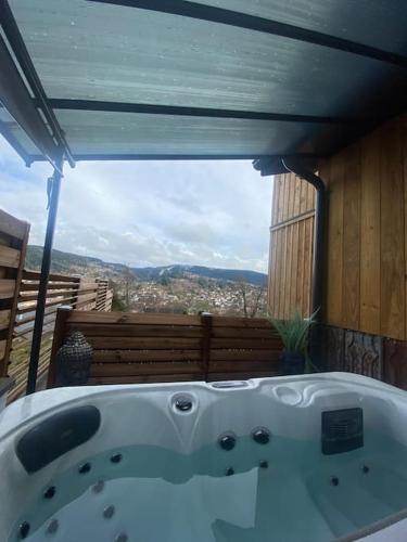 a bath tub on a balcony with a view at appartement la fleur d'abeille avec une belle vue et spa in Gérardmer