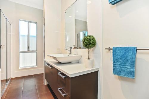 a bathroom with a sink and a mirror at Riversea Goolwa Beach House in Goolwa