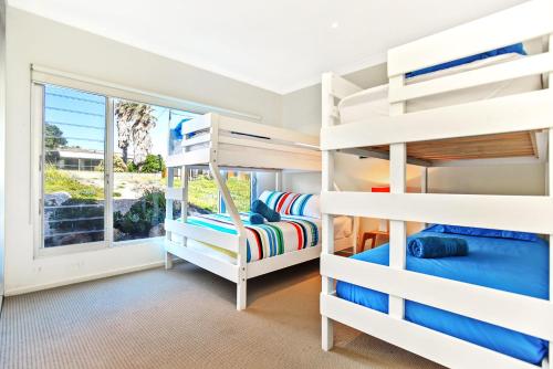 a bedroom with bunk beds and a window at Riversea Goolwa Beach House in Goolwa