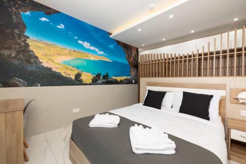 une chambre avec un lit et un tableau au mur dans l'établissement Ivory Suite Seafront With Views!- Fl 15 By Homely, à San Pawl il-Baħar