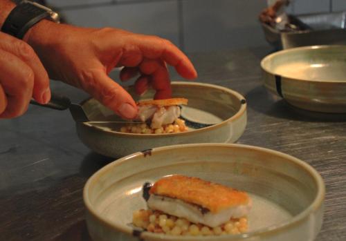 a person putting a piece of food in a bowl at Bella Vista Hôtel, Suites & Maisons in Porticcio
