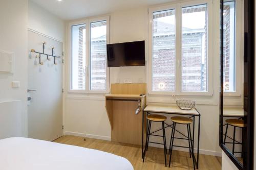 - une petite cuisine avec deux tabourets de bar dans une pièce dans l'établissement Appartement 5 proche de la gare et du centre ville, à Amiens