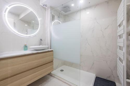 une salle de bain blanche avec un lavabo et un miroir dans l'établissement Appartement - Cannes - Terrasse, à Cannes