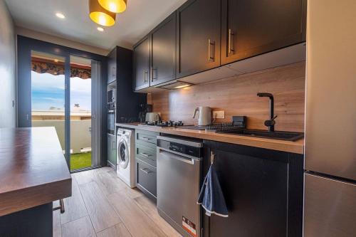 une cuisine avec un évier et un lave-vaisselle dans l'établissement Appartement - Cannes - Terrasse, à Cannes