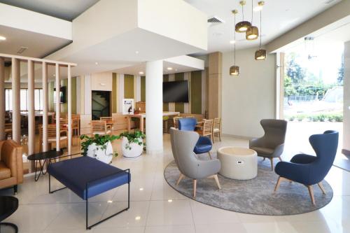 a lobby with chairs and tables and a dining area at Holiday Inn Tijuana Zona Rio by IHG in Tijuana