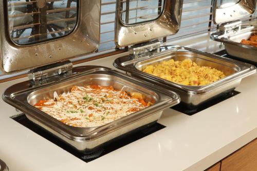 two trays of food on a counter in a kitchen at Holiday Inn Tijuana Zona Rio by IHG in Tijuana